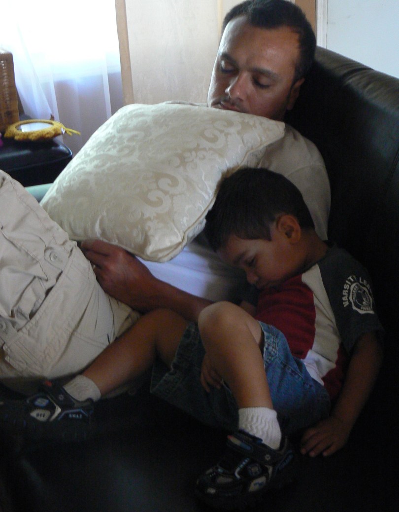 father and son fall asleep on couch