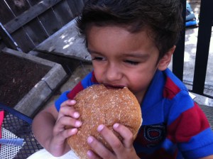 little boy eating hamburger
